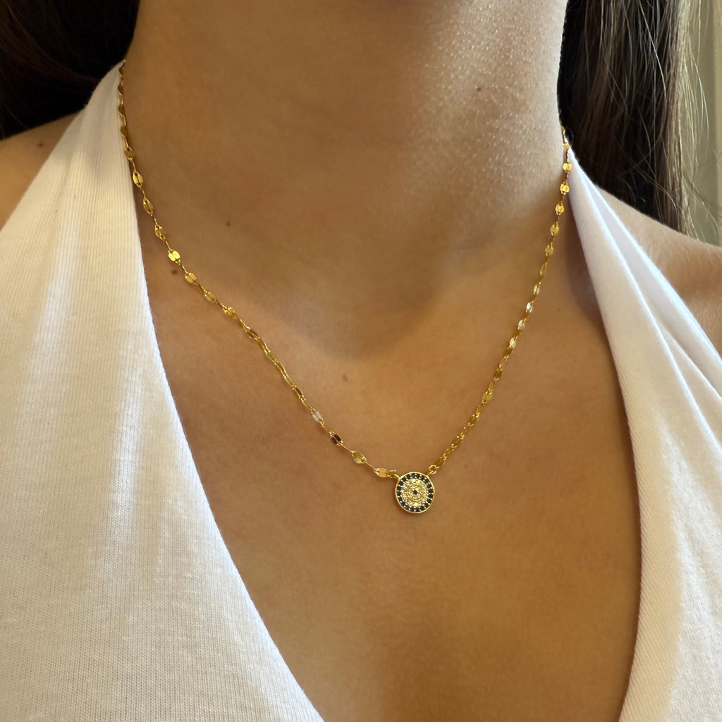 Gold evil eye necklace on model 